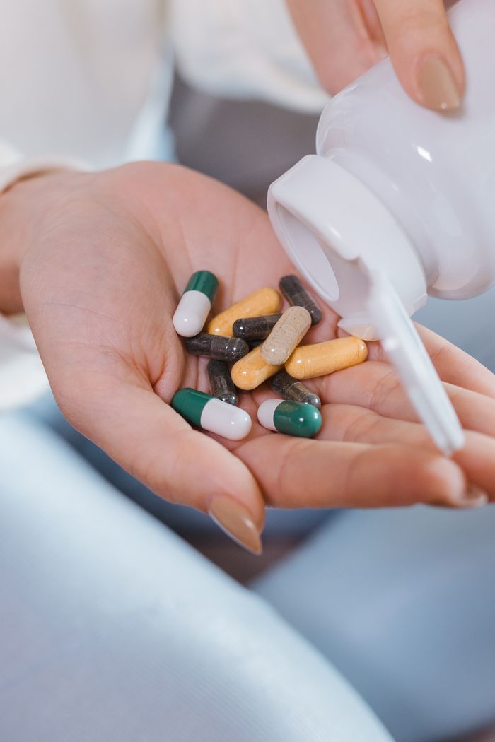 Close-up of a hand holding various pills, symbolizing healthcare and medication.